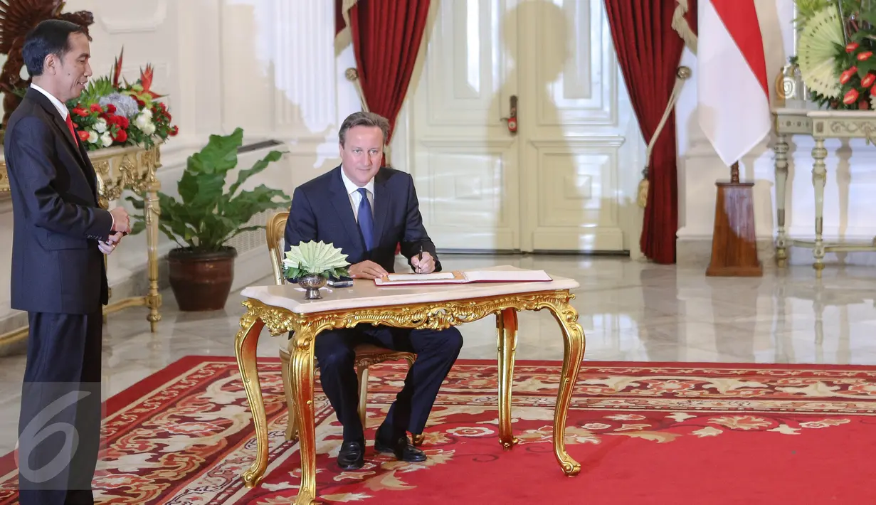 PM Inggris David Cameron (kanan) ditemani Presiden Jokowi mengisi buku tamu di Istana Negara, Jakarta, Senin (27/7). Keduanya melakukan pertemuan bilateral untuk meningkatkan hubungan kerjasama kedua negara di berbagai bidang. (Liputan6.com/Faizal Fanani)