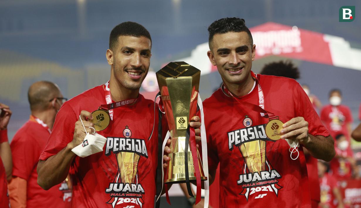 Pemain Persija Jakarta, Yann Motta (kiri) bersama Otavio Dutra berpose bersama trofi usai menjuarai Piala Menpora 2021 di Stadion Manahan, Solo, Minggu (25/4/2021). (Bola.com/M Iqbal Ichsan)