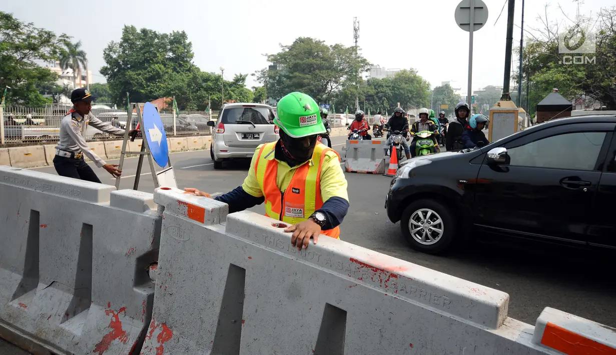 Petugas memasang penutup di Jalan Pramuka Sari IIi, Jakarta, Jumat (21/7). Uji coba pengalihan arus lalu lintas terkait pembangunan underpass Matraman dan berlangsung hingga 27 Juli mendatang. (Liputan6.com/Helmi Fithriansyah)