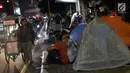 Pencari suaka duduk-duduk di luar tenda di atas trotoar depan Masjid Ar-Rayan, Jalan Kebon Sirih, Jakarta, Jumat (5/7/2019). Para pencari suaka ini membangun tenda-tenda dan meminta kepastian perlindungan dari UNHCR . (Liputan6.com/Helmi Fithriansyah)