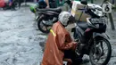Pengendara mengecek sepeda motornya setelah menerjang genangan air di Jalan Sukarjo Wiryopranoto, Jakarta, Jumat (24/1/2020). Hujan deras yang mengguyur Jakarta sejak pagi tadi mengakibatkan Jalan Sukarjo Wiryopranoto tergenang air sekitar 30 cm. (merdeka.com/Imam Buhori)