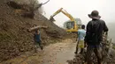 Alat berat diturunkan untuk memperbaiki jalan yang terkena longsor di Tuba, Filipina (6/7/2015). Akibat badai aktivitas penerbangan, pelabuhan dan sekolah-sekolah ditutup. (REUTERS/Harley Palangchiao)