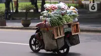 Warga membawa bahan makanan dengan sepeda motor saat melintas di kawasan Tangerang, Banten, Rabu (16/2/2022).Bank Indonesia (BI) memperkirakan terjadi penurunan harga komoditas atau deflasi pada Februari 2022. (Liputan6.com/Angga Yuniar)