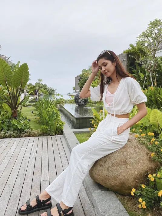 Untuk celana, Mikha memilih warna putih dengan atasan crop top putih yang chic dan stylish. [@miktambayong]