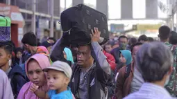Sejumlah pemudik mengantre di pintu keberangkatan Stasiun Pasar Senen, Jakarta, Selasa (12/6). Pada H-3 Lebaran, sebanyak 25.295 pemudik berangkat ke berbagai daerah di Pulau Jawa melalui Stasiun Pasar Senen. (Liputan6.com/Faizal Fanani)