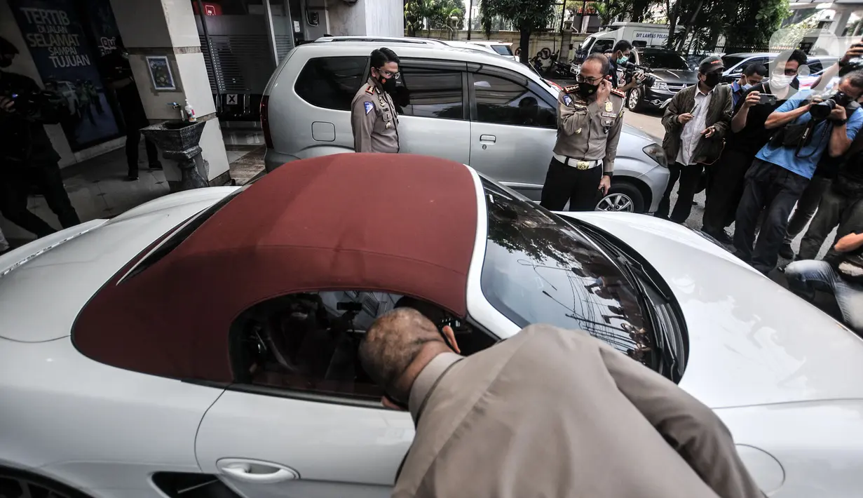 Awak media mengambil gambar mobil Porsche saat disita di Kantor Ditlantas Polda Metro Jaya, Jakarta, Senin (26/4/2021).Pemilik nobil tersebut melakukan pelanggaran menerobos jalur Transjakarta di kawasan Pondok Indah serta menghebohkan media sosial pada 18 April lalu. (merdeka.com/Iqbal S. Nugroho)