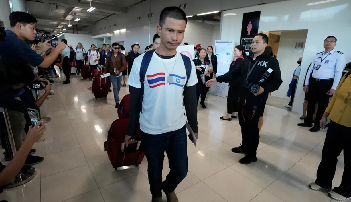 Seorang pria Thailand yang mengenakan baju berbendera Israel- Thailand tiba di Bandara Internasional Suvarnabhumi, Provinsi Samut Prakarn, Thailand, Kamis (30/11/2023). Sebanyak 17 sandera asal Thailand yang dibebaskan oleh Hamas usai berminggu-minggu ditahan di Jalur Gaza, telah mendarat di Bangkok pada Kamis (30/11) waktu setempat. (AP Photo/Sakchai Lalit)