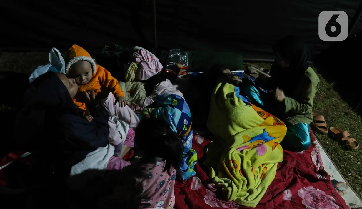 Warga terdampak gempa saat mengungsi di posko pengungsian di Taman Prawatasari, Kabupaten Cianjur, Jawa Barat, Selasa (22/11/2022). Gubernur Jawa Barat Ridwan Kamil menyebut, sebanyak 14 posko pengungsian didirikan untuk memfasilitasi warga berjumlah 13.784 pengungsi yang terdampak gempa berkekuatan 5,6 SR di Kabupaten Cianjur. (Liputan6.com/Herman Zakharia)