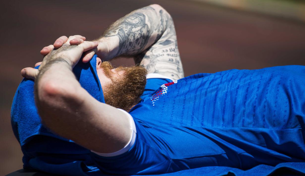Tato pemain Islandia, Aron Gunnarsson dilengan kiri saat tertidur sebelum berlatih jelang Euro Cup 2016 di d'Albigny sports center, Annecy le Vieux, (10/6/2016). (AFP/Odd Andersen)