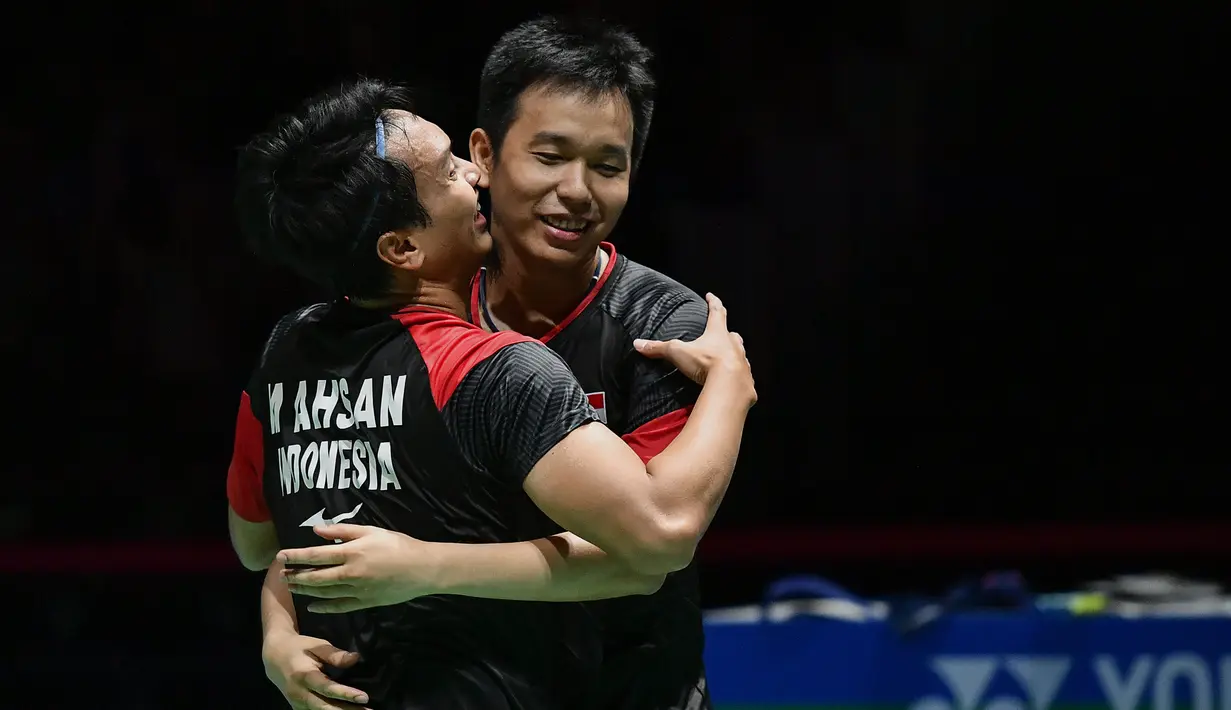 Ganda putra Indonesia Hendra Setiawan dan Mohammad Ahsan merayakan kemenangan atas ganda putra Jepang Takuro Hoki dan Yugo Kobayashi pada babak final Kejuaraan Dunia Bulu Tangkis 2019 di Swiss, Minggu (25/8/2019). Ahsan/Hendra menang dengan skor 25-23, 9-21, 21-15. (FABRICE COFFRINI/AFP)