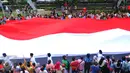 Bendera merah putih berukuran besar diarak saat karnaval perayaan Cap Go Meh di Glodok, Jakarta, (21/2). Perayaan yang merupakan rangkaian terakhir perayaan Imlek itu diikuti 1477 peserta dengan menampilkan berbagai kesenian. (Liputan6.com/Faisal R Syam)