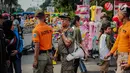 Petugas Satpol PP melakukan sosialisasi saat menertibkan PKL di kawasan car free day (CFD), Bundaran HI, Jakarta, Minggu (4/8/2019). Penertiban dilakukan karena keberadaan PKL membuat tidak nyaman pengunjung CFD yang ingin berolahraga, berorasi, atau sekadar jalan-jalan. (Liputan6.com/Faizal Fanani)