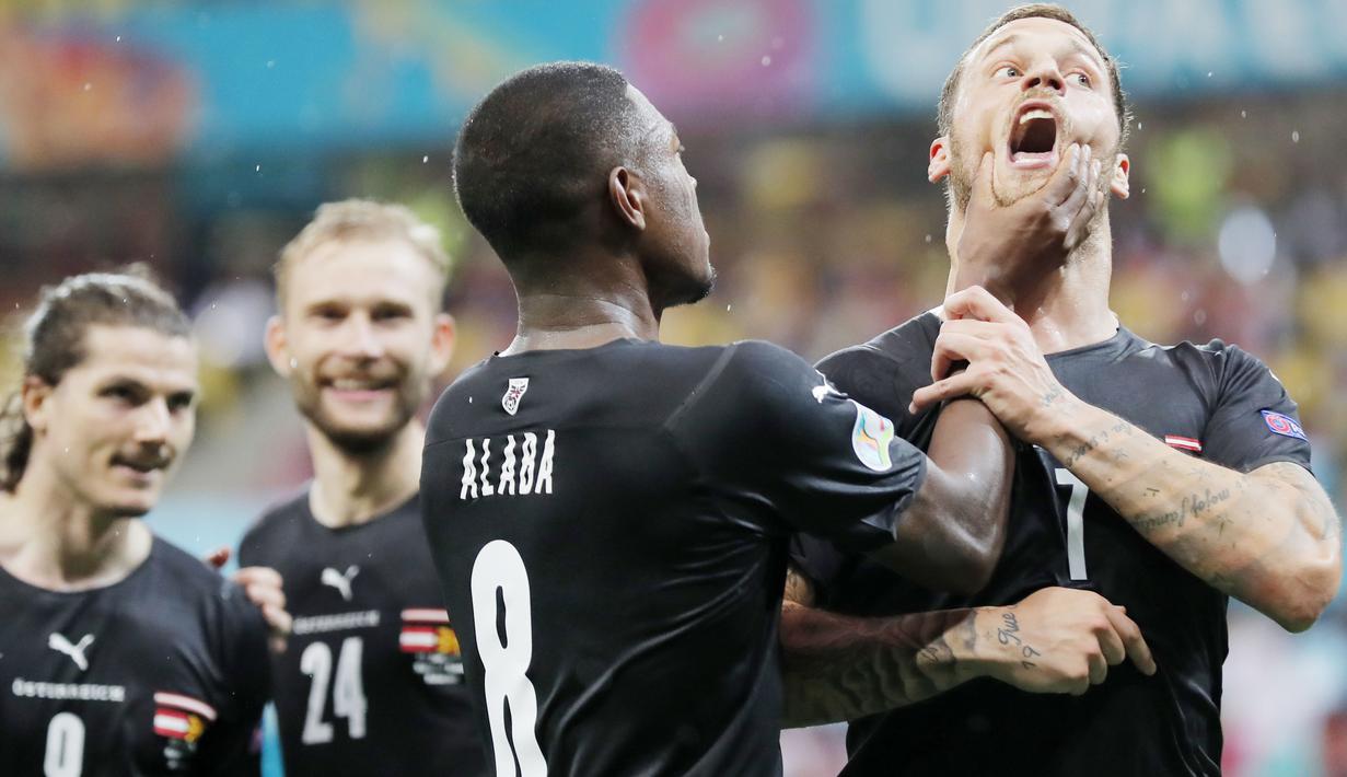 Kapten Austria, David Alaba, meremas mulut Marko Arnautovic saat merayakan gol ke gawang Makedonia Utara. Aksi itu dilakukan Alaba karena rekannya tersebut terindikasi melakukan Selebrasi Berbau Rasis. (Robert Ghement/Pool via AP)