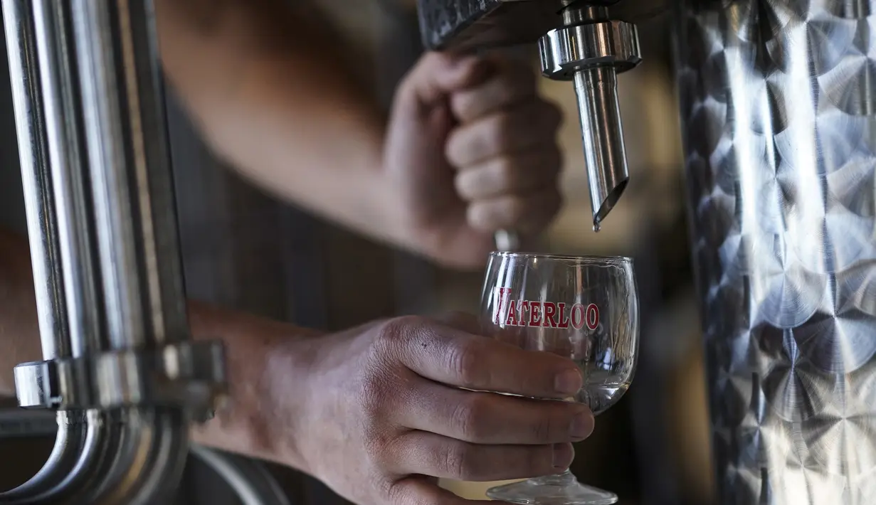 Manajer Waterloo Microdistillery, Edward Martin bekerja di Mont-Saint-Jean Farm, Waterloo, Belgia, Selasa (7/4/2020). Di tengah pandemi virus corona COVID-19, pabrik sopi dan wiski Mont-Saint-Jean Farm beralih memproduksi alkohol medis. (Kenzo TRIBOUILLARD/AFP)
