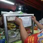 Petugas Satpol PP menempelkan stiker penutupan sementara tempat makan saat penertiban penerapan PSBB di wilayah Kecamatan Pulogadung, Jakarta, Jumat (18/9/2020). Malam, Razia dilakukan memastikan ketidakadaannya konsumen makan ditempat tersebut. (merdeka.com/Imam Buhori)