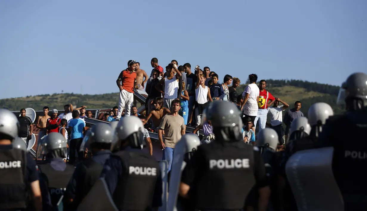 Beberapa warga pinggiran kota Roma, Stara Zagora, Bulgaria, mencoba melakukan protes saat aparat kepolisian akan menggusur tempat tinggal mereka, (21/7/2014). (REUTERS/Stoyan Nenov)