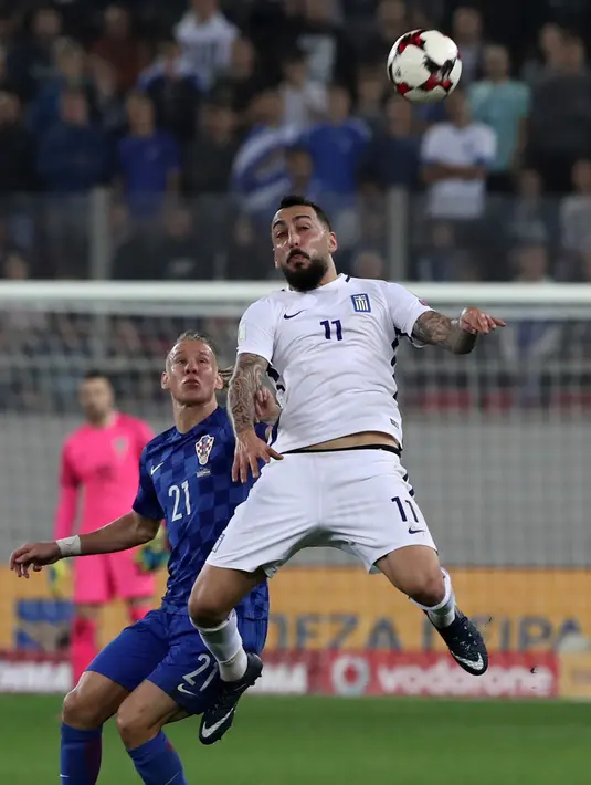 Pemain Yunani, Kostas Mitroglou berebut bola dengan pemain Kroasia, Domagoj Vida pada laga leg kedua play-off Piala Dunia 2018 di Stadion Karaiskakis, Senin (13/11). Kroasia menang dengan agregat 4-1 atas Yunani. (AP/Yorgos Karahalis)