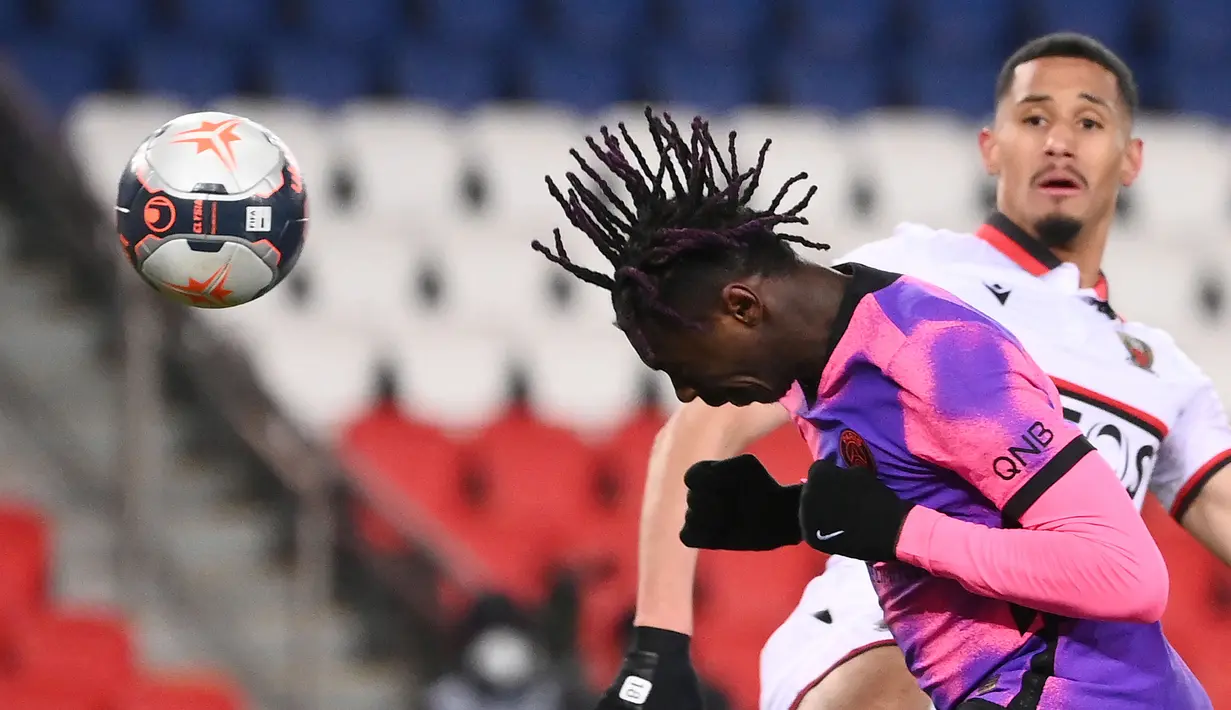 Striker Paris Saint-Germain, Moise Kean (kiri) melepaskan sundulan yang berbuah gol kedua timnya ke gawang OGC Nice dalam laga lanjutan Liga Prancis 2020/21 pekan ke-25 di Parc des Princes Stadium, Paris, Sabtu (13/2/2021). Paris Saint-Germain menang 2-1 atas Nice. (AFP/Franck Fife)