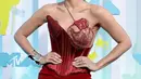 Penyanyi kelahiran Brasil, Anitta tampil glamor dan nyentrik mengenakan gaun merah yang menampilkan rok kolom ramping dan korset sutra. Gaun ini terlihat mencolok dengan detail sulaman rumit berbentuk jantung yang menutupi satu sisi dadanya. (Instagram/anitta).