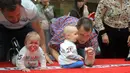 Sejumlah bayi bereaksi saat mengikuti lomba merangkak untuk memperingati Hari Anak Internasional di Vilnius, Lithuania, Kamis (1/6). Orang tua memberikan iming-iming benda kesukaan buah hatinya saat mengikuti lomba. (Petras Malukas/AFP)