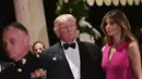 Melania Trump mendampingi Donald Trump saat menghadiri gala tahunan Palang Merah Amerika ke-60 di Mar-a-Lago, Florida, AS (4/2). First Lady Melania Trump tampil anggun dengan mengenakan gaun berwarna merah muda. (AFP/Mandel Ngan)
