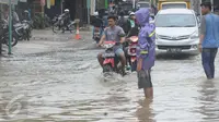 Sejumlah kendaraan melintasi banjir di jalan Merpati Raya kota,Tangerang Selatan, Selasa (21/2). Intensitas curah hujan yang tinggi di sertai buruknya Drainase menyebabkan banjir 50-100 cm di kawasan tersebut. (Liputan6.com/Helmi Afandi)