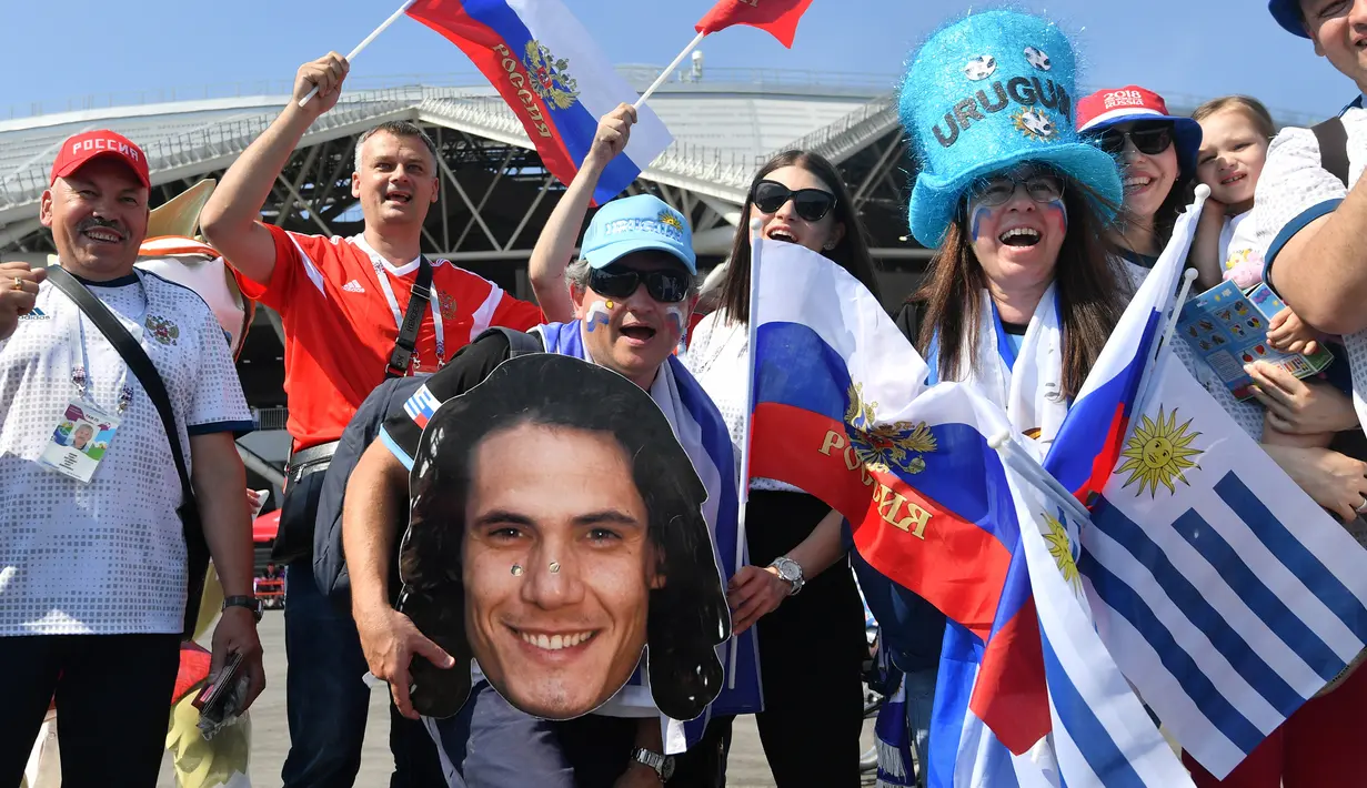 Suporter Uruguay dan Rusia foto bersama jelang laga kedua negara dalam penyisihan Grup A Piala Dunia 2018 di Samara Arena, Samara, Rusia, Senin (25/6). (EMMANUEL DUNAND/AFP)