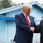 Presiden AS, Donald Trump bertemu dengan Pemimpin Korea Utara, Kim Jong-un di zona demiliterisasi Korea (DMZ), Desa Panmunjom pada Minggu (30/6/2019).  Pertemuan keduanya berawal ketika Trump menuliskan undangan pertemuan dengan Kim melalui Twitter. (AP Photo/Susan Walsh)