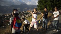 Para pemuda menerbangkan layang-layang dalam acara peringatan 400 tahun permukiman kumuh Petare di Caracas, Venezuela (17/2/2021). Kemiskinan tetap menjadi kendala utama perkembangan kota ini. (AP Photo/Ariana Cubillos)