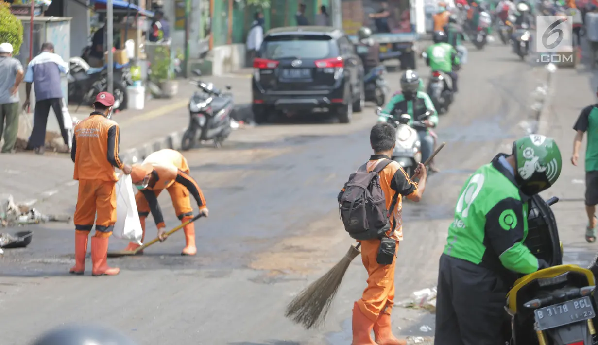 Petugas membersihkan jalan setelah bentrok massa dengan aparat di kawasan Palmerah, Jakarta, Kamis (26/9/2019). Banyak masyarakat yang melintas dan warga sekitar perih pada mata hingga bersin akibat sisa gas air mata. (Liputan6.com/Faizal Fanani)