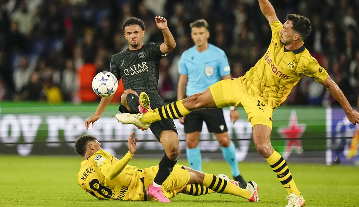 Pemain Paris Saint-Germain (PSG), Warren Zaire-Emery, berebut bola dengan pemain Borussia Dortmund, Mats Hummels, pada laga Liga Champions di Stadion Parc des Princes, Rabu (20/9/2023). PSG menang dengan skor 2-0. (AP Photo/Michel Euler)