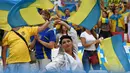 Suporter Ukraine menari sambil mengibarkan bendera sebelum laga  Euro 2016  Ukraina melawan Polandia di Stadion Velodrome, Marseille, Rabu (22/6/2016) dini hari WIB. (AFP/Anne-Christine  Poujoulat)