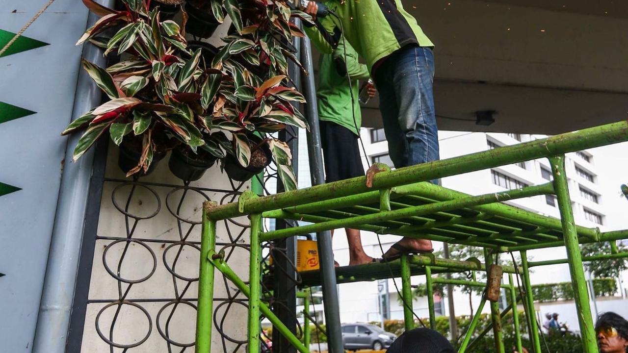 FOTO: Petugas Percantik Taman Vertikal di Kawasan Sudirman Jakarta