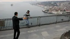Pasukan pengamanan presiden menggiring seorang pria bernama Vezir Catras, yang hendak melompat dari jembatan Bosphorus saat iring-iringan Presiden Tayyip Erdogan melintas di Istanbul, Turki, (26/12/2015). (Reuters)