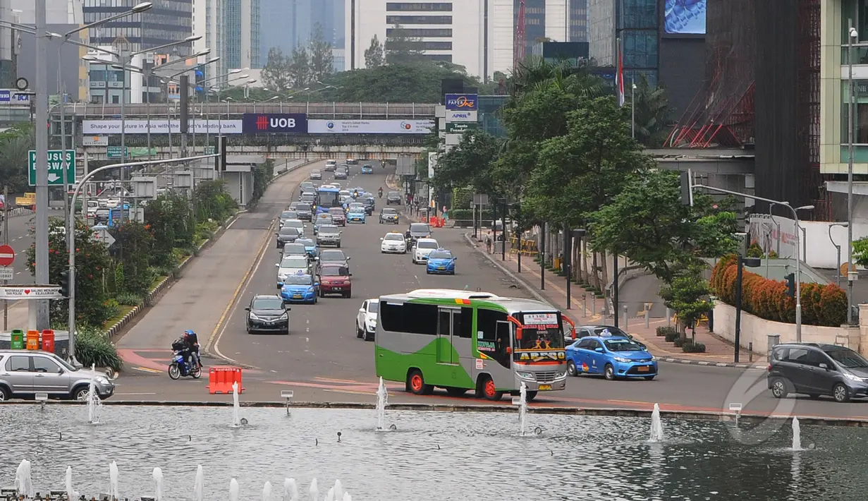 Sejumlah kendaraan saat melintas di kawasan Bundaran HI, Jakarta, Jumat (3/4/2015).  Kondisi jalanan lengang disebabkan libur panjang yang bertepatan libur paskah dan banyaknya masyarakat Jakarta yang berlibur ke luar kota. (Liputan6.com/Herman Zakharia)