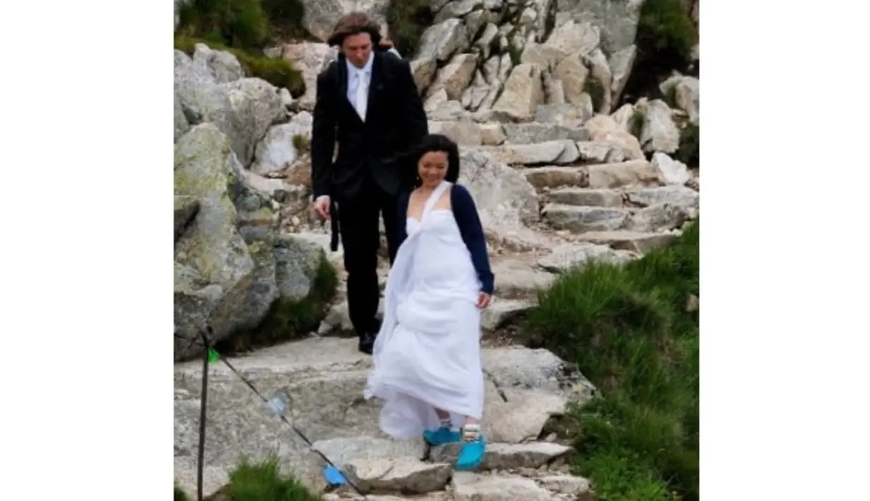 Tampilan nyentrik terlihat ketika ia menuruni tebing dalam balutan gaun putih yang begitu kontras. [Foto: Instagram/ Prof. Stella Christie]