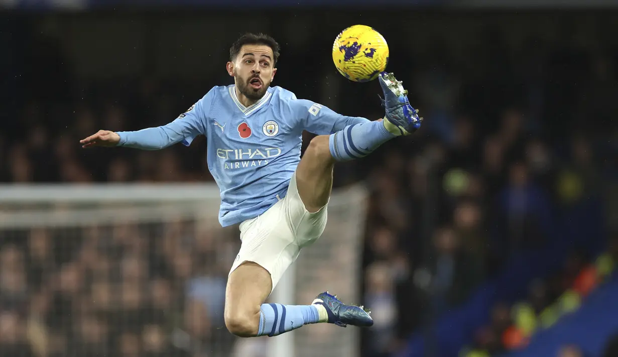 Gelandang Manchester City Bernardo Silva mengontrol bola di udara saat bertandang ke markas Chelsea pada laga pekan ke-12 Premier League 2023/2024 di Stamford Bridge, Minggu (12/11/2023) malam WIB. (AP Photo/Ian Walton)