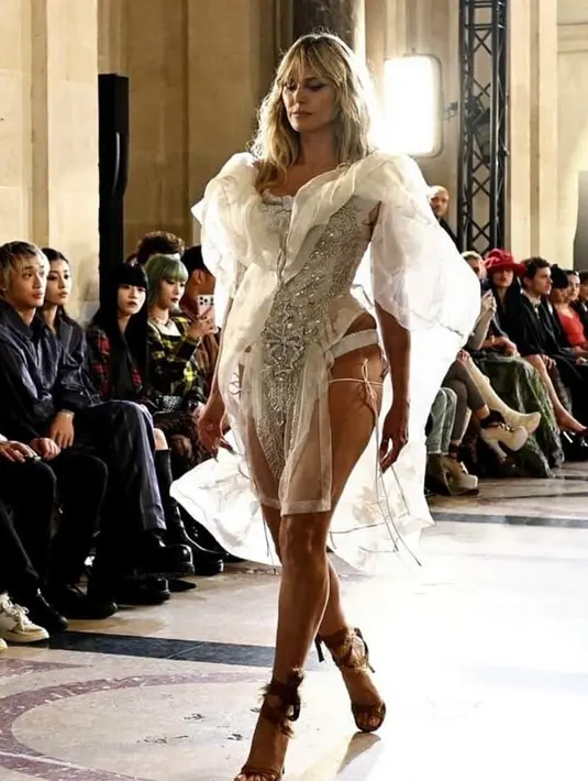 <p>Heidi Klum tampil sebagai penutup fashion show tersebut. Klum pun tampil mengenakan busana siluet korset yang dihiasi beads dengan teil organza. Dipadukan heels tali coklat. [@heidiklum]</p>