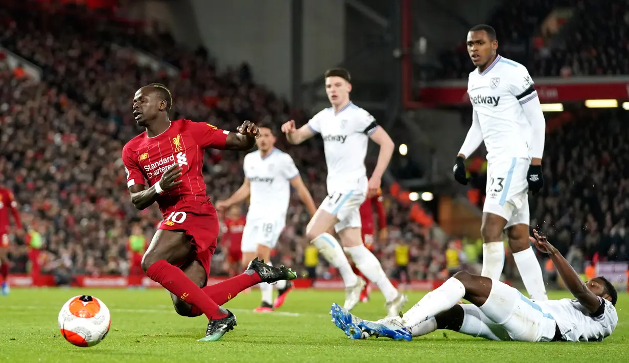 Pemain Liverpool Sadio Mane terjatuh saat membawa bola dekat gawang West Ham pada pertandingan Liga Inggris di Stadion Anfield, Liverpool, Inggris, Senin (24/2/2020). Liverpool mengalahkan West Ham dengan skor 3-2. (AP Photo/Jon Super)