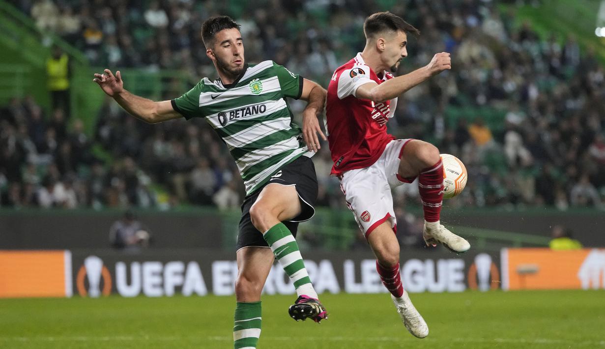 Pemain Sporting CP, Goncalo Inacio (kiri) berebut bola dengan pemain Arsenal, Fabio Vieira pada laga leg pertama Liga Europa 2022/2023 di Jose Alvalade Stadium, Lisbon, Jumat (10/03/2023) dini hari WIB. Laga berakhir dengan skor imbang 2-2. (AP Photo/Armando Franca)