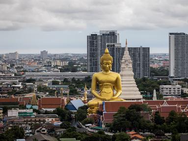 Patung Buddha raksasa setinggi 69 meter berdiri di kuil Wat Paknam Phasi Charoen di pinggiran Bangkok, Thailand pada Selasa (12/10/2021). Patung raksasa yang mulai dibangun tahun 2017 dan ukurannya setinggi gedung 20 lantai ini menghiasi langit kota metropolitan Bangkok. (Jack TAYLOR / AFP)