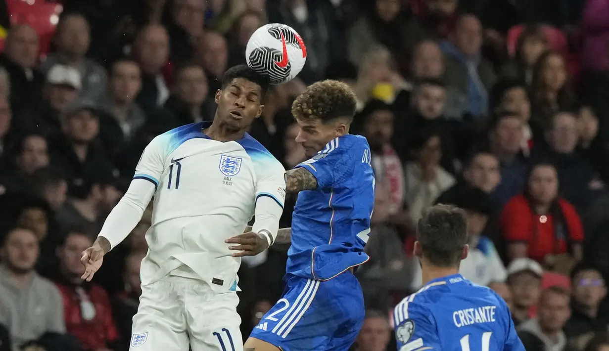 Pemain Timnas Inggris, Marcus Rashford (kiri), berebut bola di udara dengan pemain Timnas Italia, Giovanni Di Lorenzo (tengah) dalam laga lanjutan Kualifikasi Euro 2024 yang digelar di Wembley, London pada Rabu (18/10/2023) dini hari WIB. Rashford berhasil mencetak satu gol dalam pertandingan ini. (AP Photo/Frank Augstein)