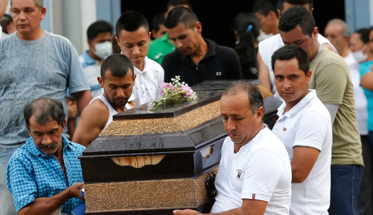 Warga membawa peti jenazah korban banjir dan tanah longsor sebelum dimakamkan di Mocoa, Kolombia, (3/4). Musibah ini memakan korban jiwa hingga ratusan orang dan menghancurkan seluruh lingkungan. (AP Photo / Fernando Vergara)