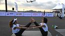 Sekitar 500 peserta yoga dan influencer yang siap dengan kamera mulai berdatangan pada pukul 5:00 pagi, berjalan dalam kegelapan menuju matras mereka di landasan pacu. (MANAN VATSYAYANA / AFP)