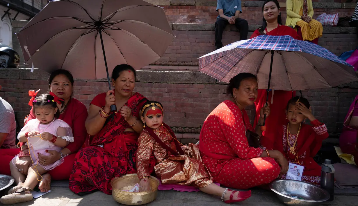 Anak-anak perempuan di bawah usia sembilan tahun berkumpul untuk mengikuti tradisi pemujaan. (AP Photo/Niranjan Shrestha)