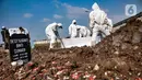 Petugas mengenakan baju hazmat saat memakamkan jenazah pasien Covid-19 di TPU Rorotan, Jakarta, Minggu (28/3/2021). Hingga hari ini sudah ada 9 jenazah pasien Covid-19 dimakamkan di TPU Rorotan yang berkapasitas 1.500 petak makam tersebut. (merdeka.com/Iqbal S. Nugroho)