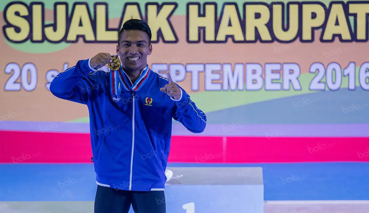 Deni menunjukan medali emas yang diraihnya usai menjadi yang terbaik di kelas 69 kilogram. (Bola.com/Vitalis Yogi Trisna)