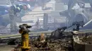 Petugas pemadam kebakaran memeriksa lokasi jatuhnya sebuah pesawat kecil jatuh di Santee, California, Senin (11/10/2021). Pesawat itu mengalami masalah dan mencoba mendarat di Gillespie Field—yang berada di dekat sebuah sekolah menengah, ketika jatuh. (AP Photo/Gregory Bull)