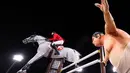 Atlet Swiss Martin Fuchs mengendarai Clooney 51 berkompetisi melewati patung pegulat sumo kecil dalam kualifikasi individu lompat berkuda selama Olimpiade Tokyo 2020 di Equestrian Park di Tokyo (3/8/2021). (AFP/Behrouz Mehri)