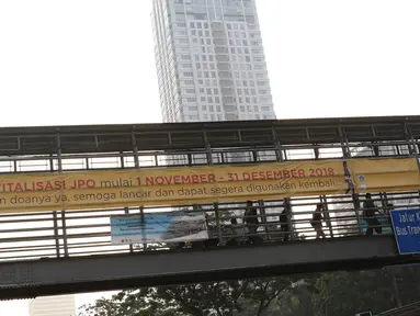 Spanduk peringatan revitalisasi Jembatan Penyeberangan Orang (JPO) di JPO Jalan Sudirman, Jakarta, Selasa (6/11). Pemprov DKI Jakarta berencana merevitalisasi tiga JPO di sepanjang Jalan Jenderal Sudirman. (Liputan6.com/Immanuel Antonius)